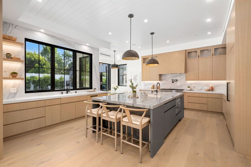 Interior de una cocina moderna, con una barra en el centro y almacenamientos de madera