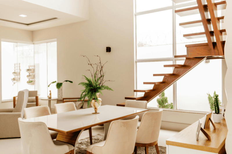 comedor residencial lleno de luz, con escaleras modernas y de madera