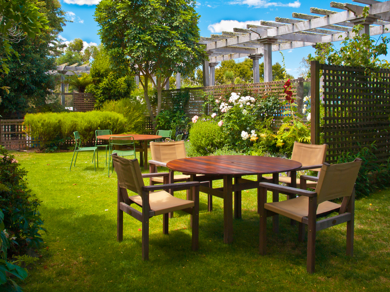 Patio elegante con jardin y un juego de mesa y sillas en un día soleado